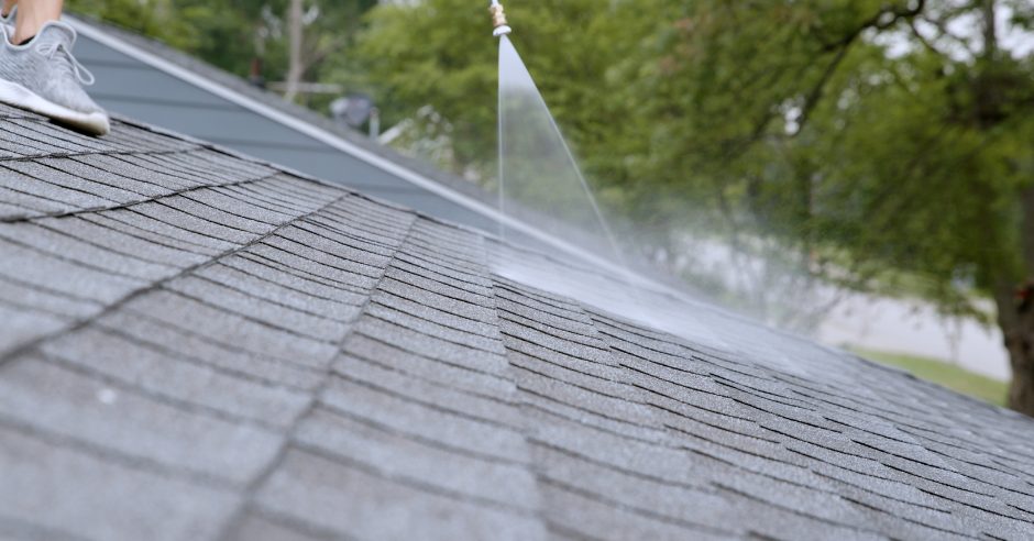 Applicator treating an asphalt shingle roof with a low-pressure sprayer